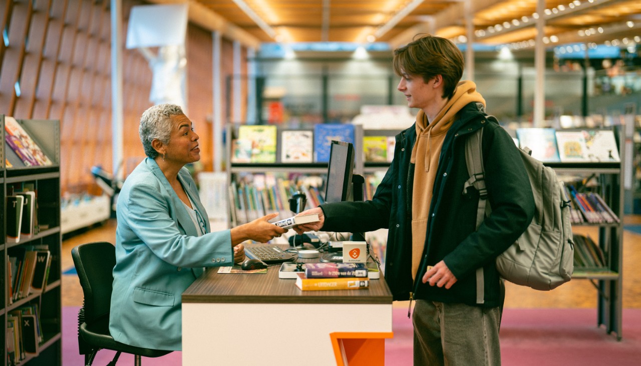 Jongen rekent boek af in de bibliotheek