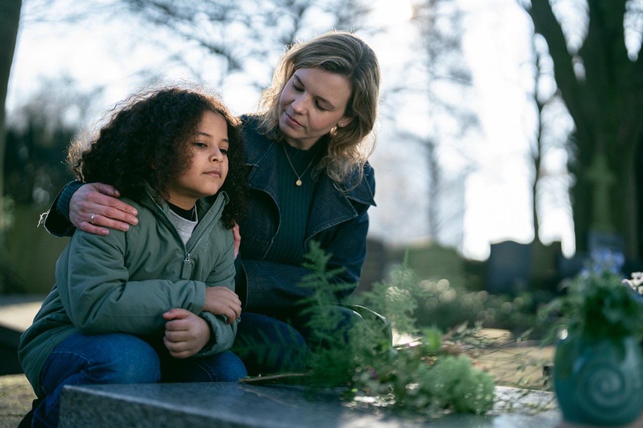 dame met kind bij graf 