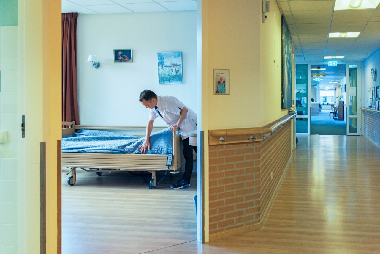 Dokter achter laptop met hoofd tegen hand