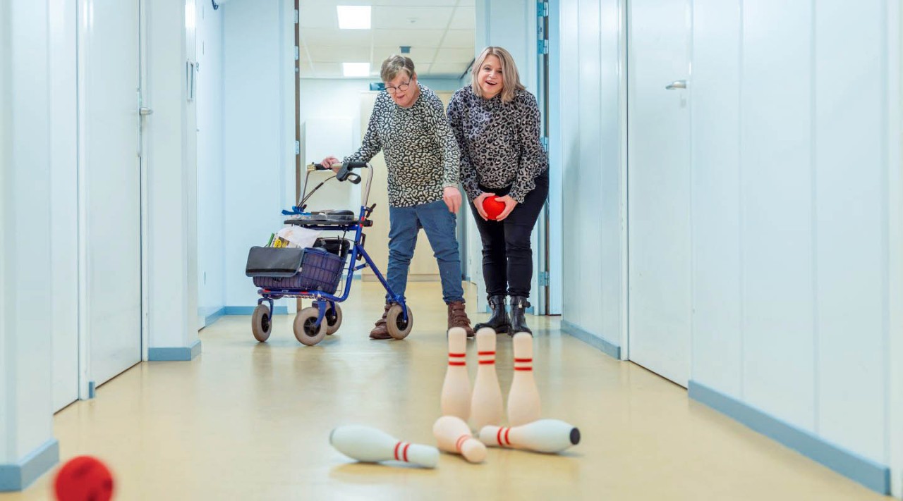 Mariëlle en patiënt bowlen in de gang