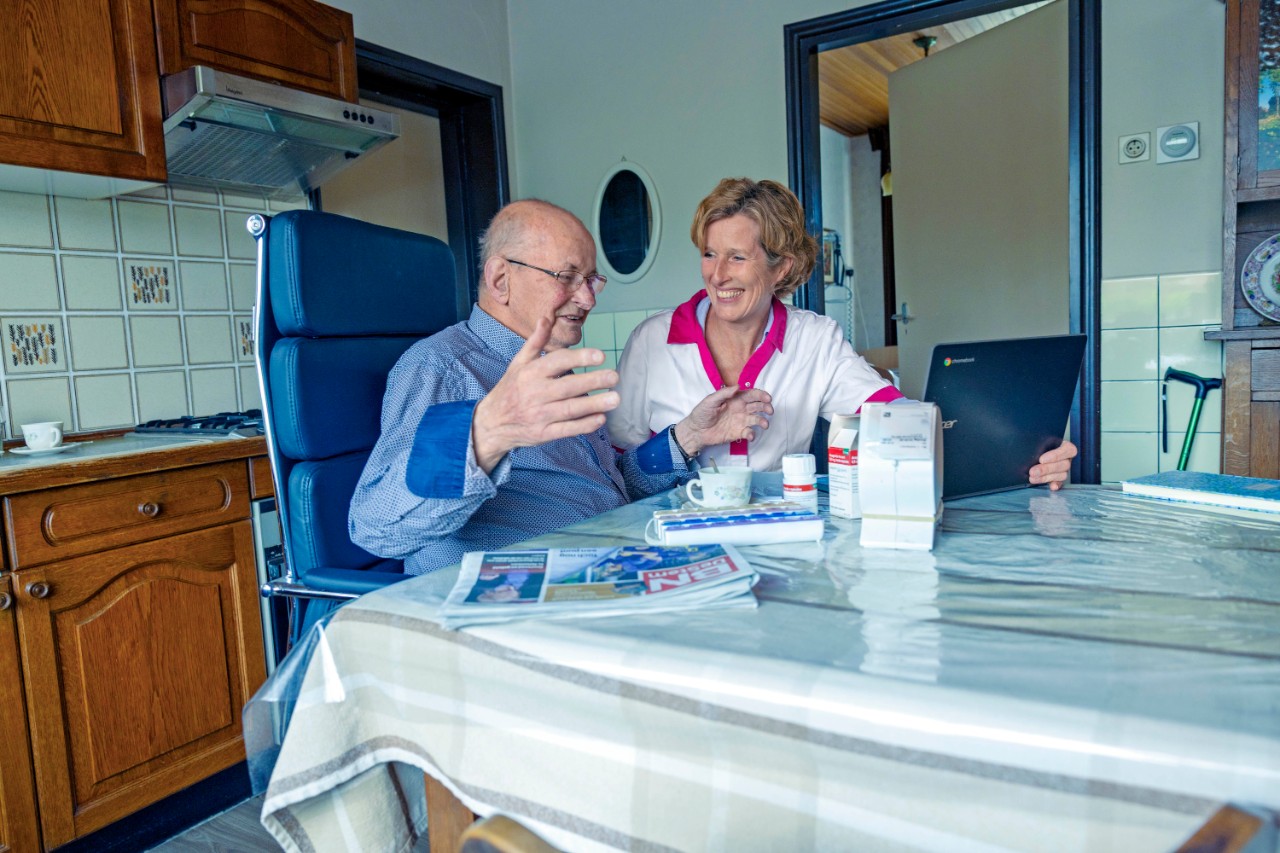 Twee vrouwen praten met elkaar zittend aan een tafel