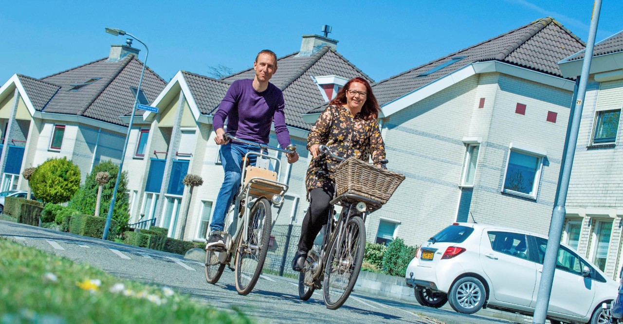 Daphne en Martin fietsen door een woonwijk