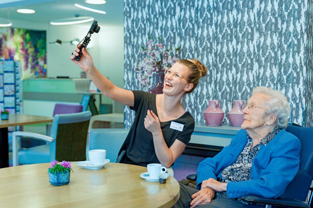 Zorgmedewerker maakt foto met zorgbehoevende