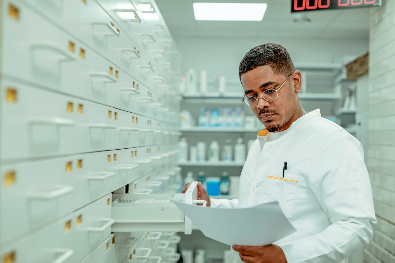 apotheker leest recept bij ladenkast diversiteit