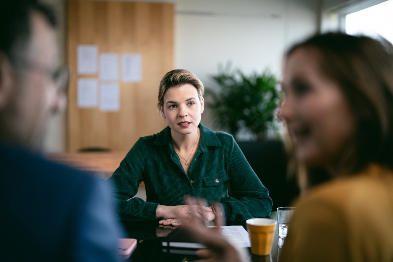 dame voert gesprek met koppel serieuze setting