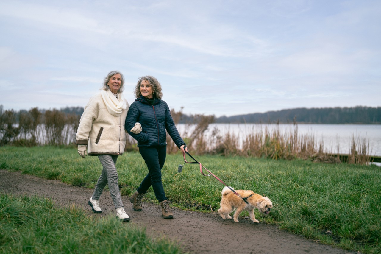 twee oudere dames wandelen met hond